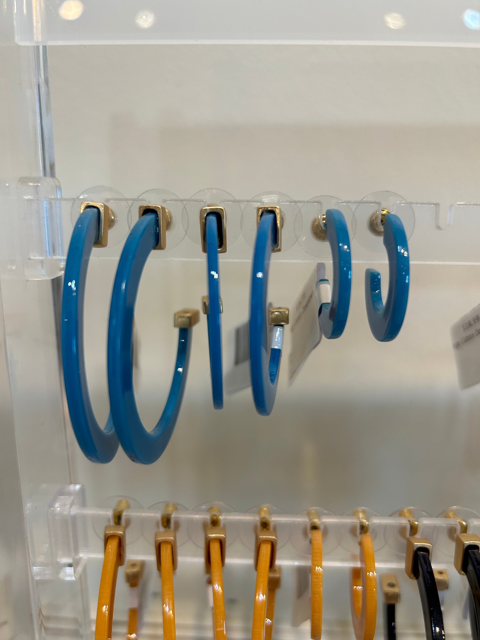 Peacock blue acrylic hoop earrings in three sizes.