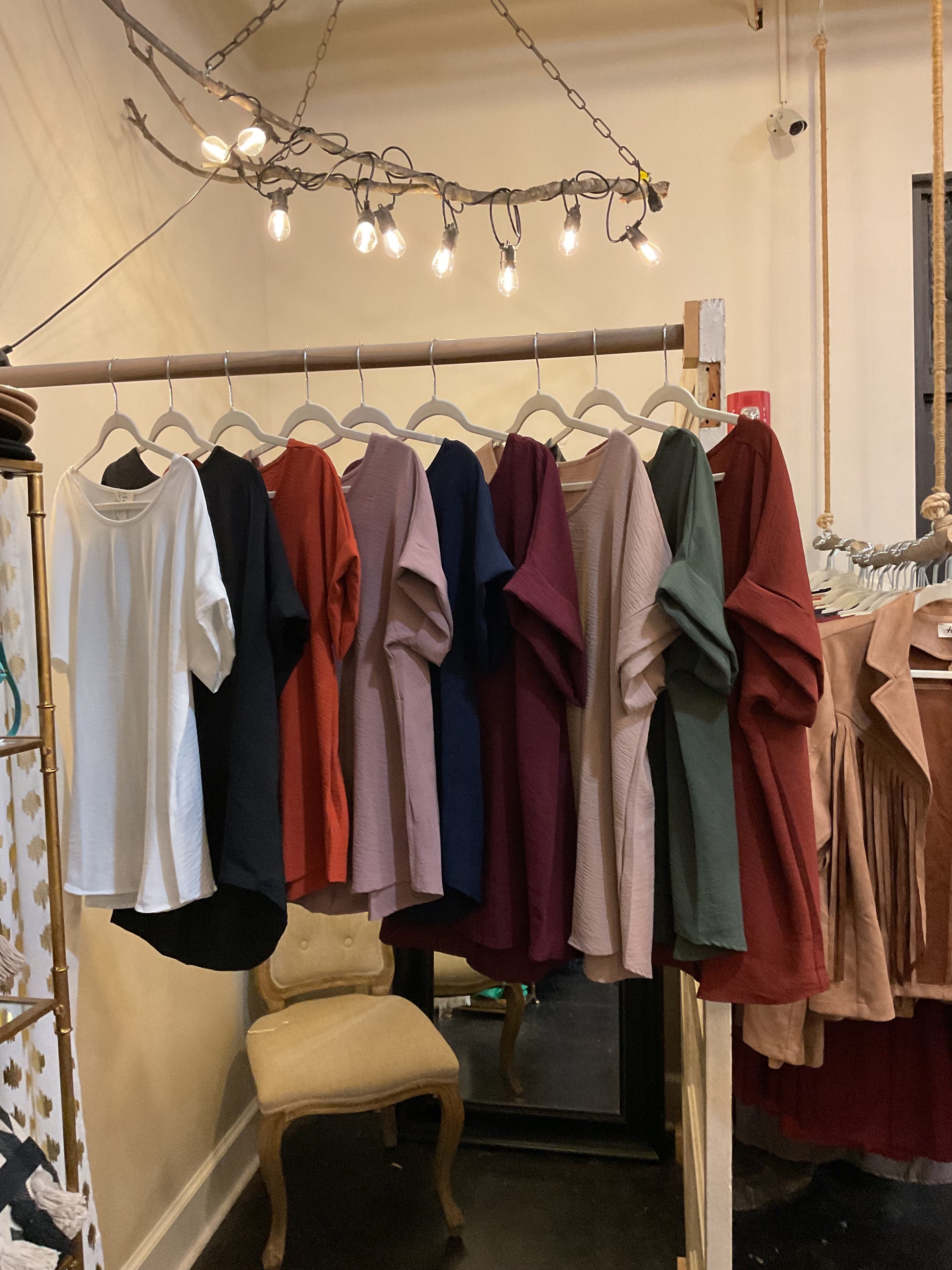 Assorted scoop-neck top featuring permanent rolled sleeve detail and an asymmetrical hem.