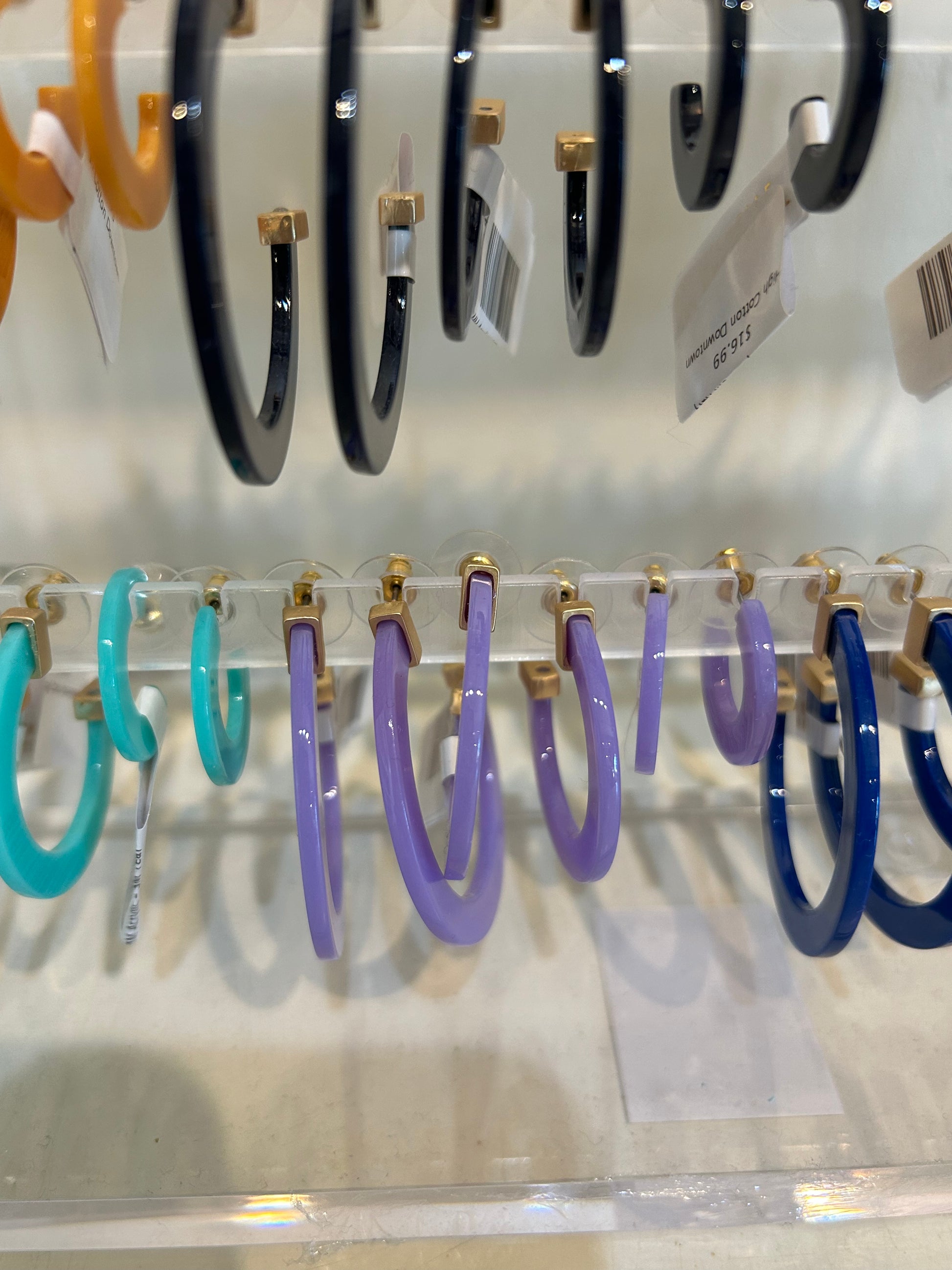 Purple acrylic hoop earrings in three sizes.