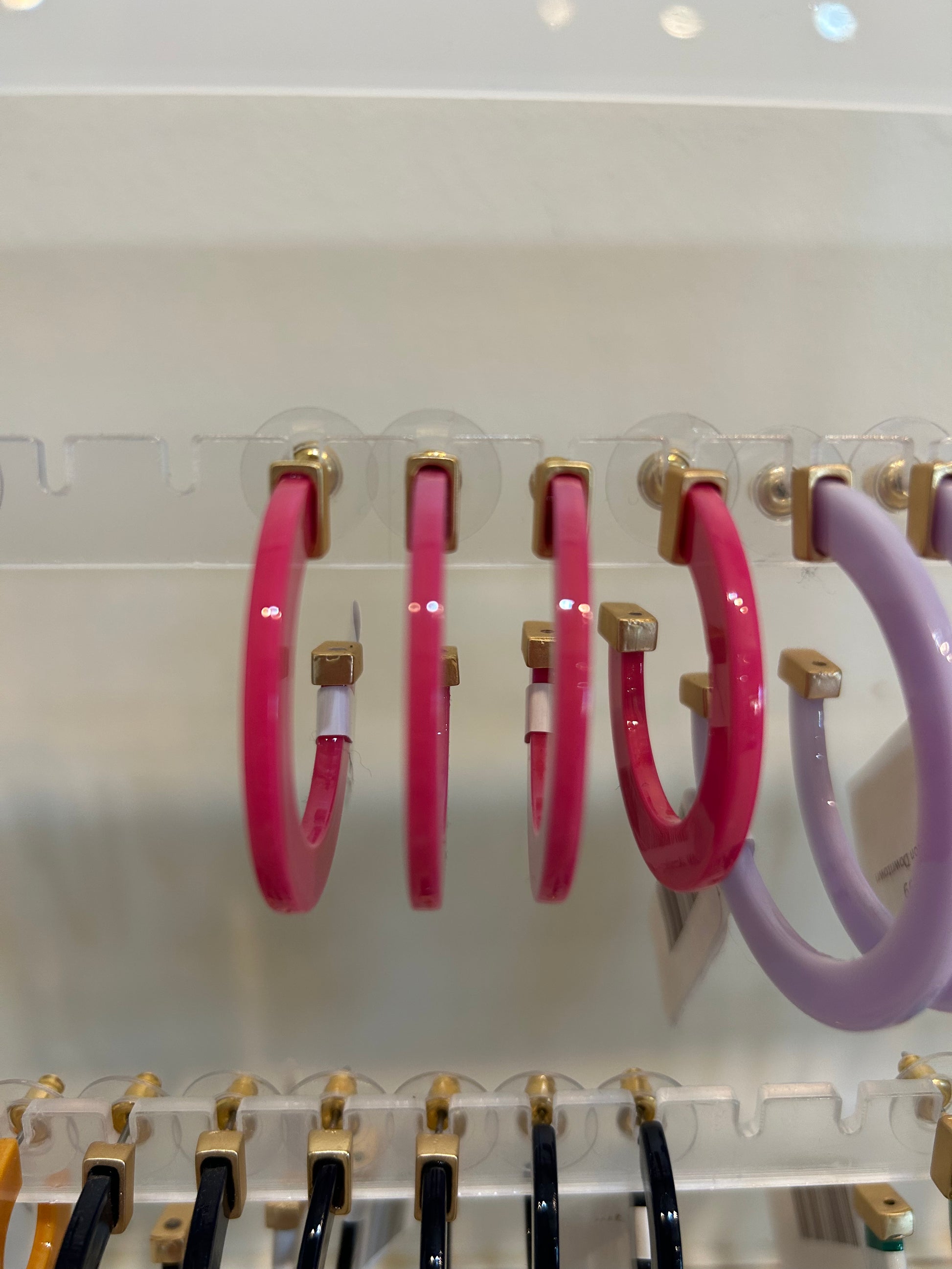 Dark pink acrylic hoop earrings.