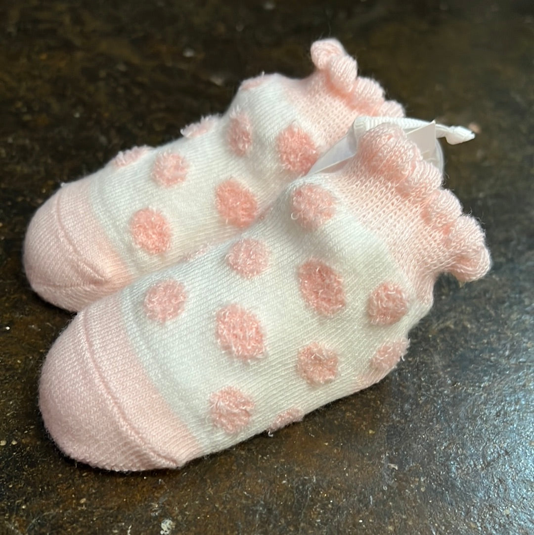 Pink and white polka dot baby socks.