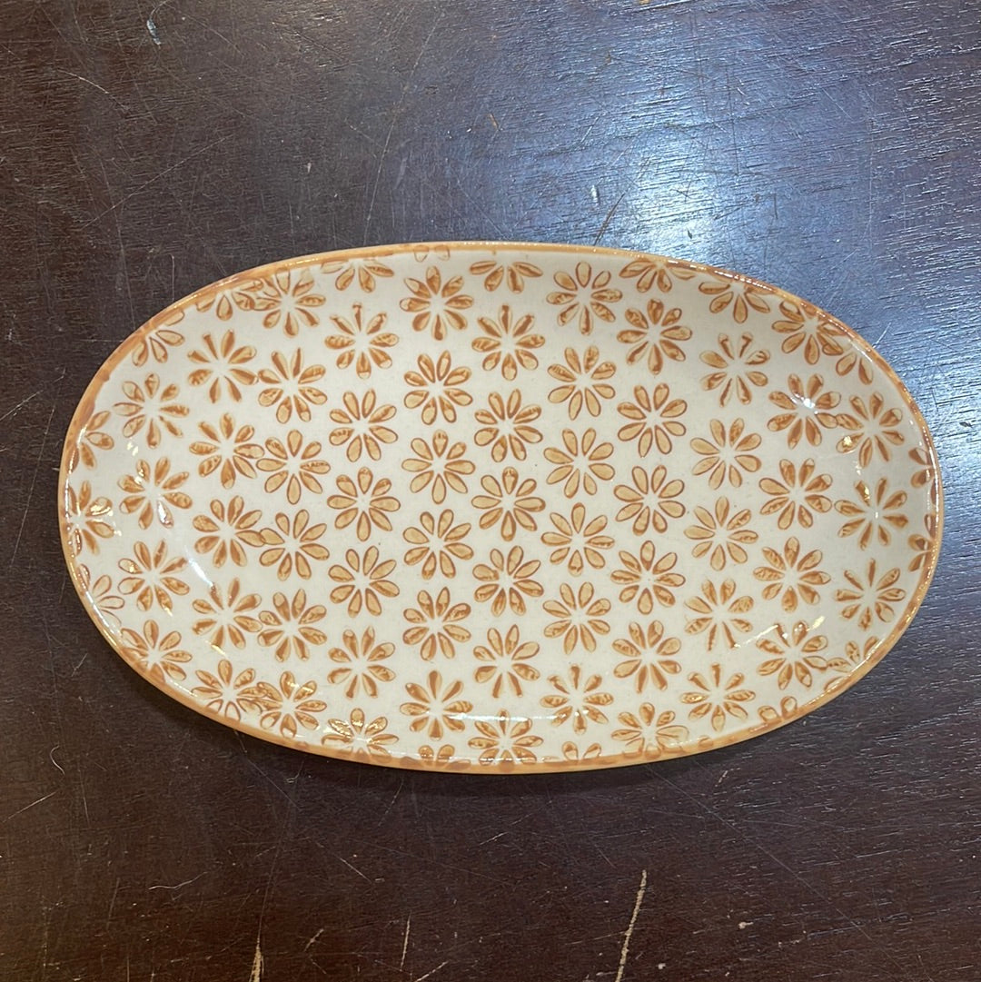 Hand stamped stoneware plate with a rust orange floral pattern.