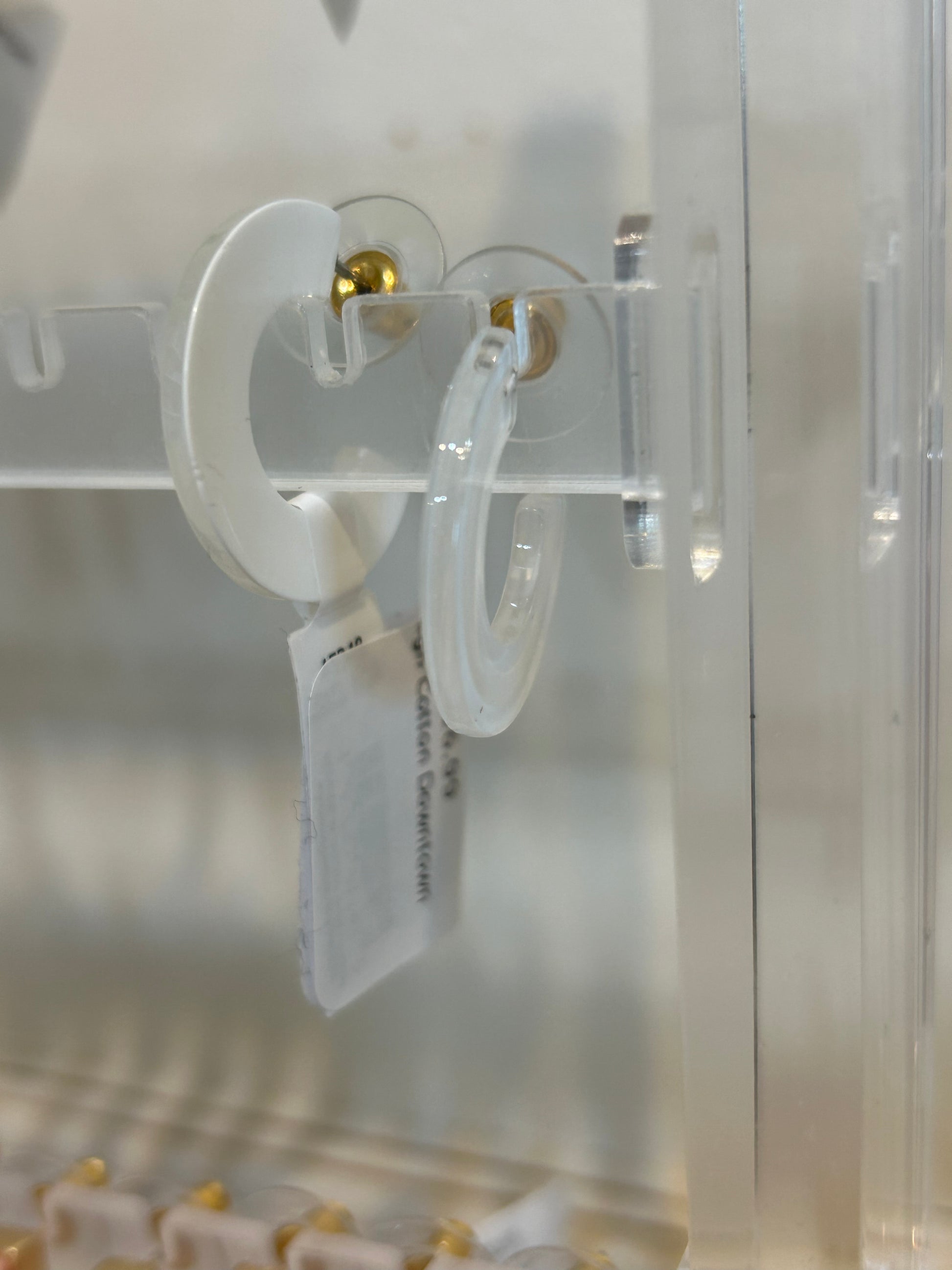 Whte acrylic hoop earrings.