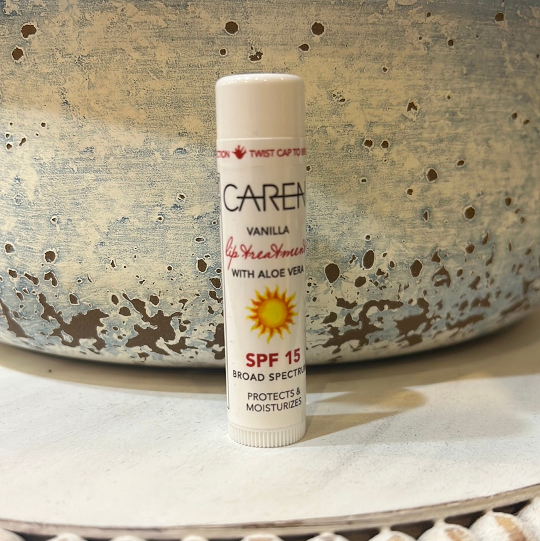 Tube of Caren vanilla lip treatment with aloe vera in white packaging with black and red lettering with a sun. SPF 15.