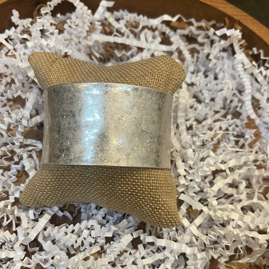 Wide silver in color bangle.