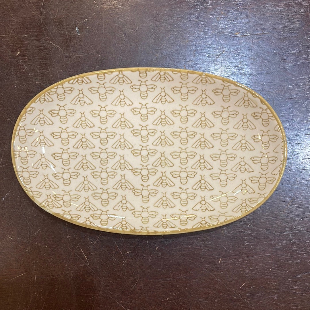 Hand stamped stoneware plate with a beige bee design.
