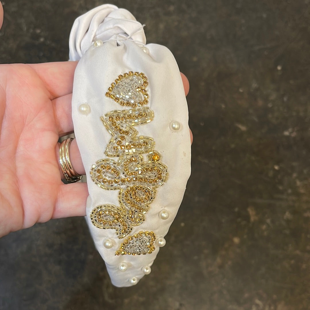 White topknot headband with "Wifey" and a heart in gold beading with pearls.