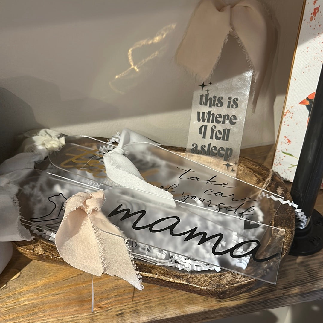 Clear acrylic bookmark with black lettering featuring differing sayings.