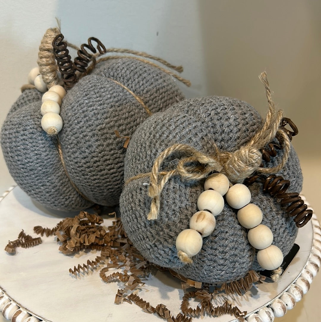 Gray knitted pumpkins with wooden beads and twine for a stem.
