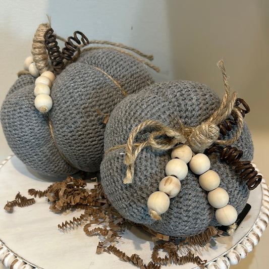 Gray knitted pumpkins with wooden beads and twine for a stem.