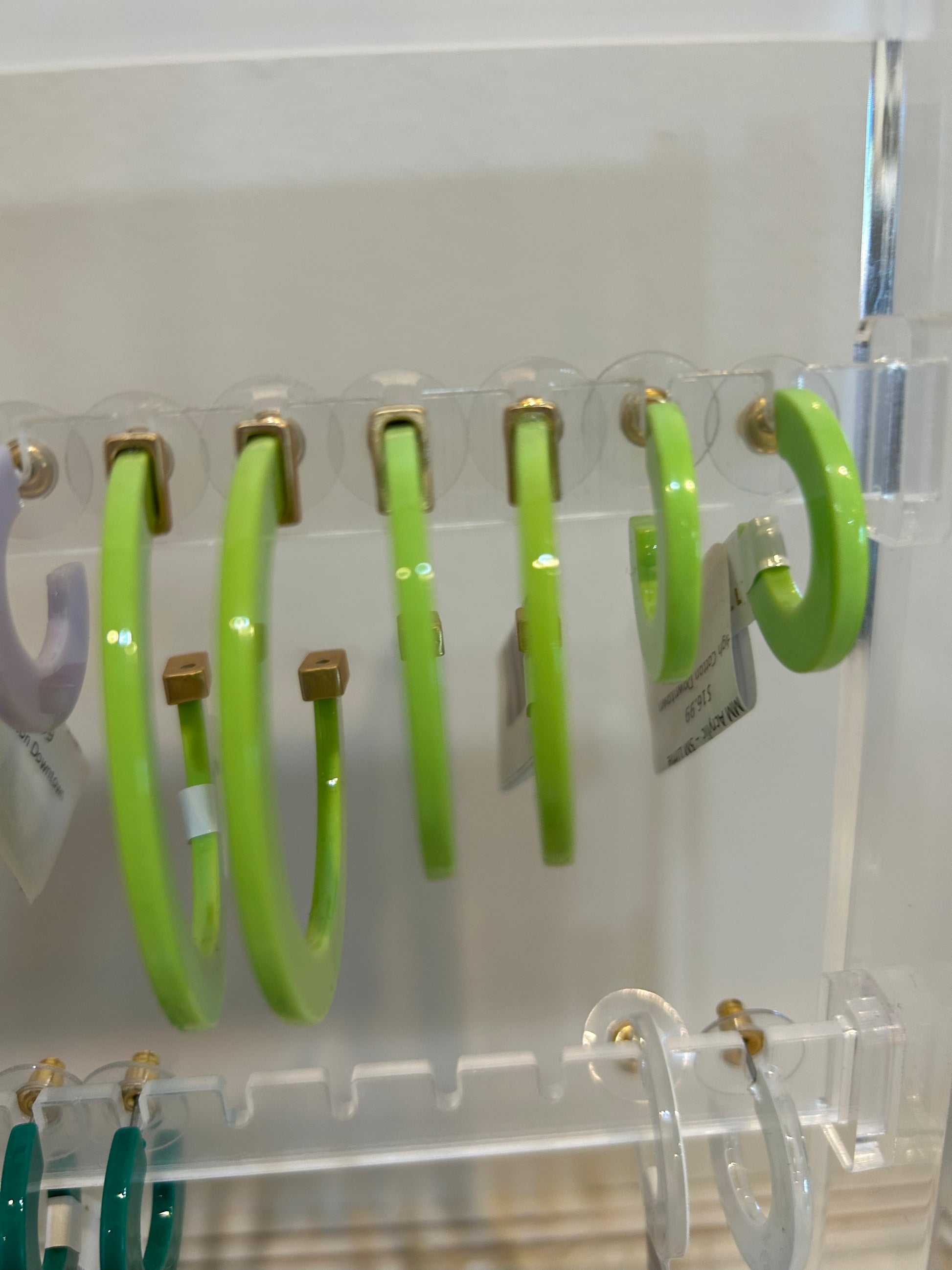 Light green acrylic hoop earrings in three sizes.
