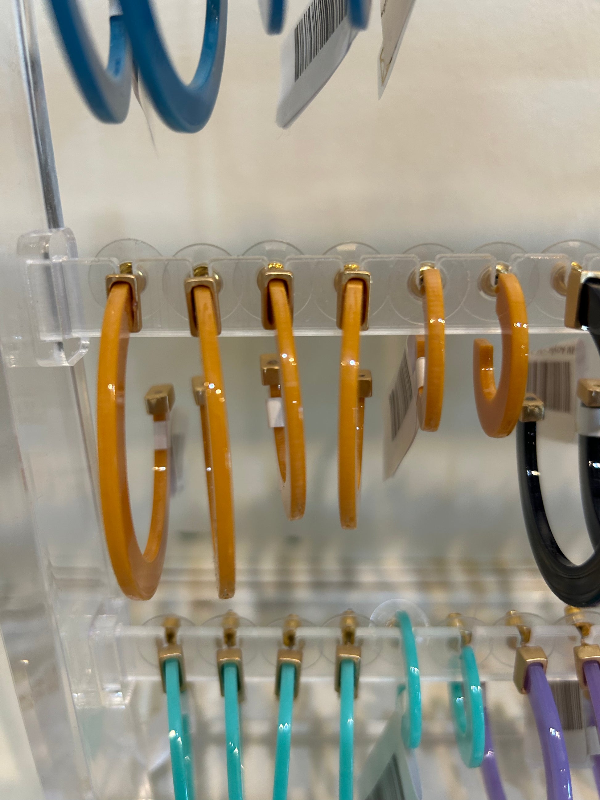 Mustard acrylic hoop earrings in three sizes.