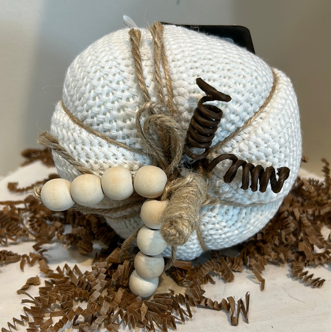 White knitted pumpkin with wooden beads and twine for a stem.