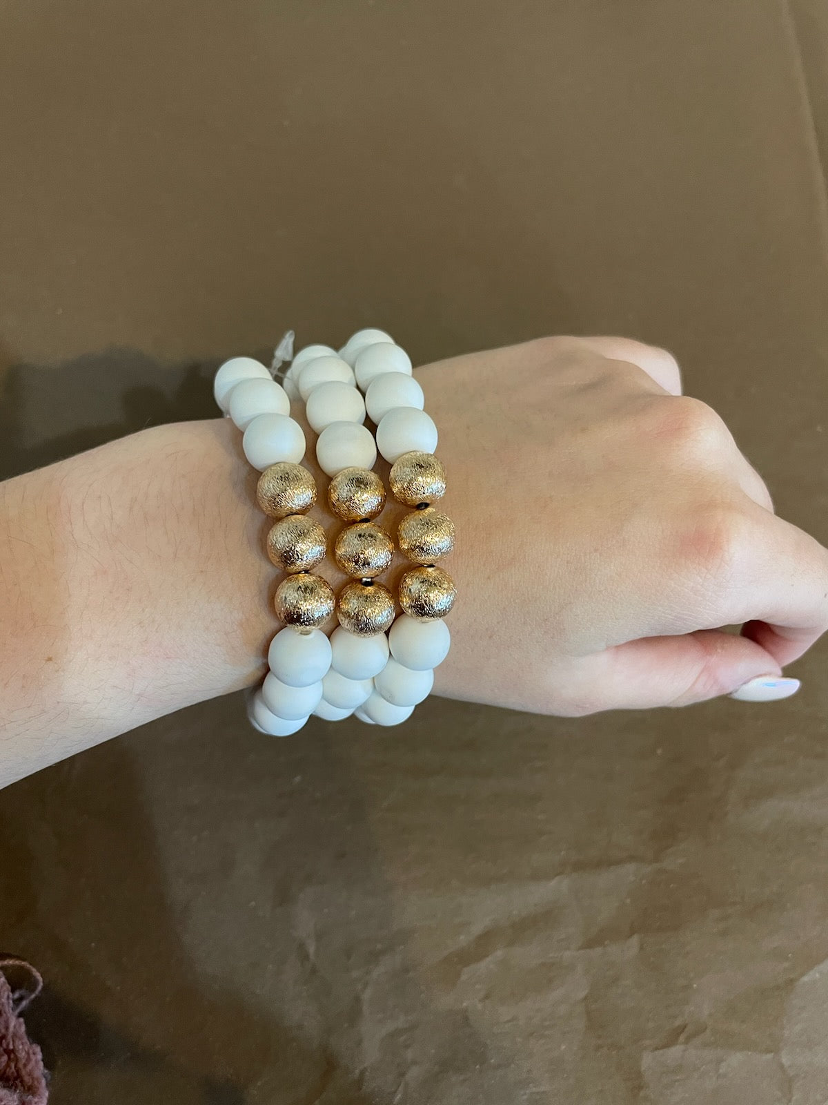 White clay textured bracelet stack with golden beads.