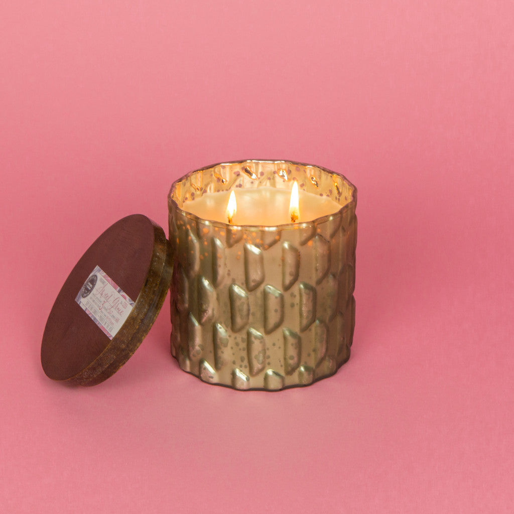 Candle in a gray, textured mercury glass jar.