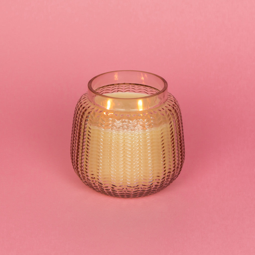 Candle in a globe-shaped jar with lilac hues.