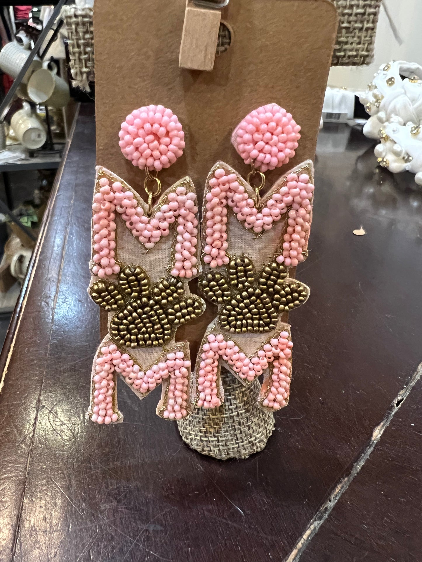 Pink and gold beaded dangle earrings featuring "MOM" with the "O" being a paw print.