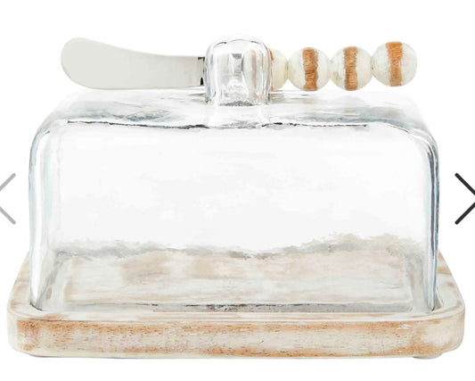 Glass butter dish with white-washed wooden base and white-washed beaded spreader.