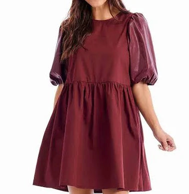 Model featuring burgundy dress with leather puff sleeves.