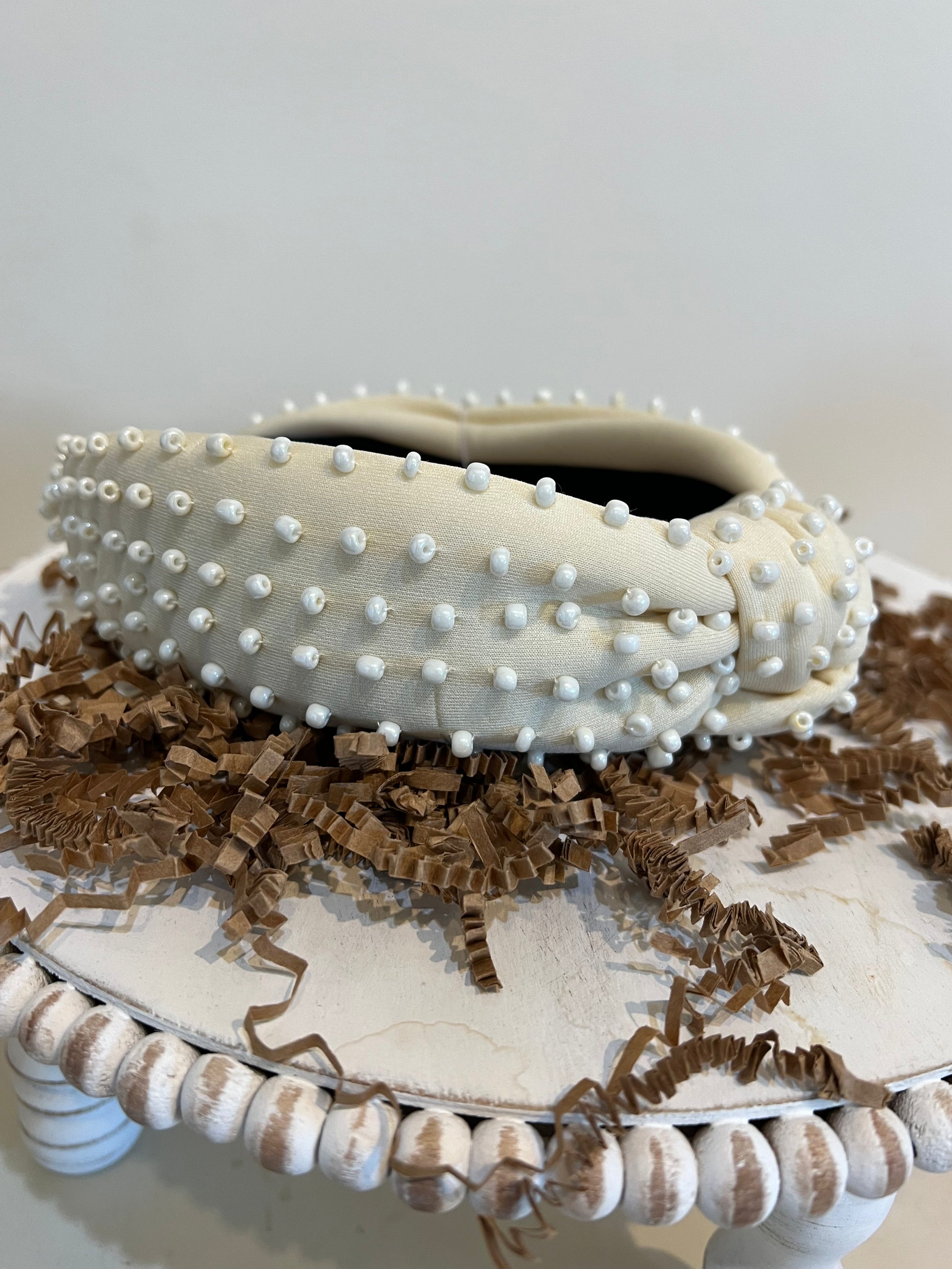 Cream top knot headband with white beads.