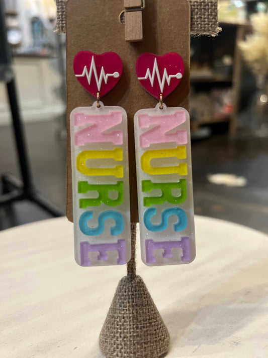 Dangle earrings with a heartbeat stud featuring "NURSE" in pink, yellow, green, blue, and purple acrylic.