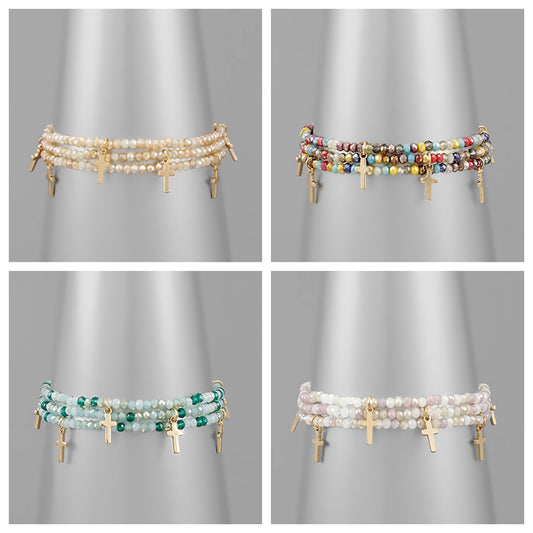 Assorted cross bracelets with cross charms and varying colored beads.