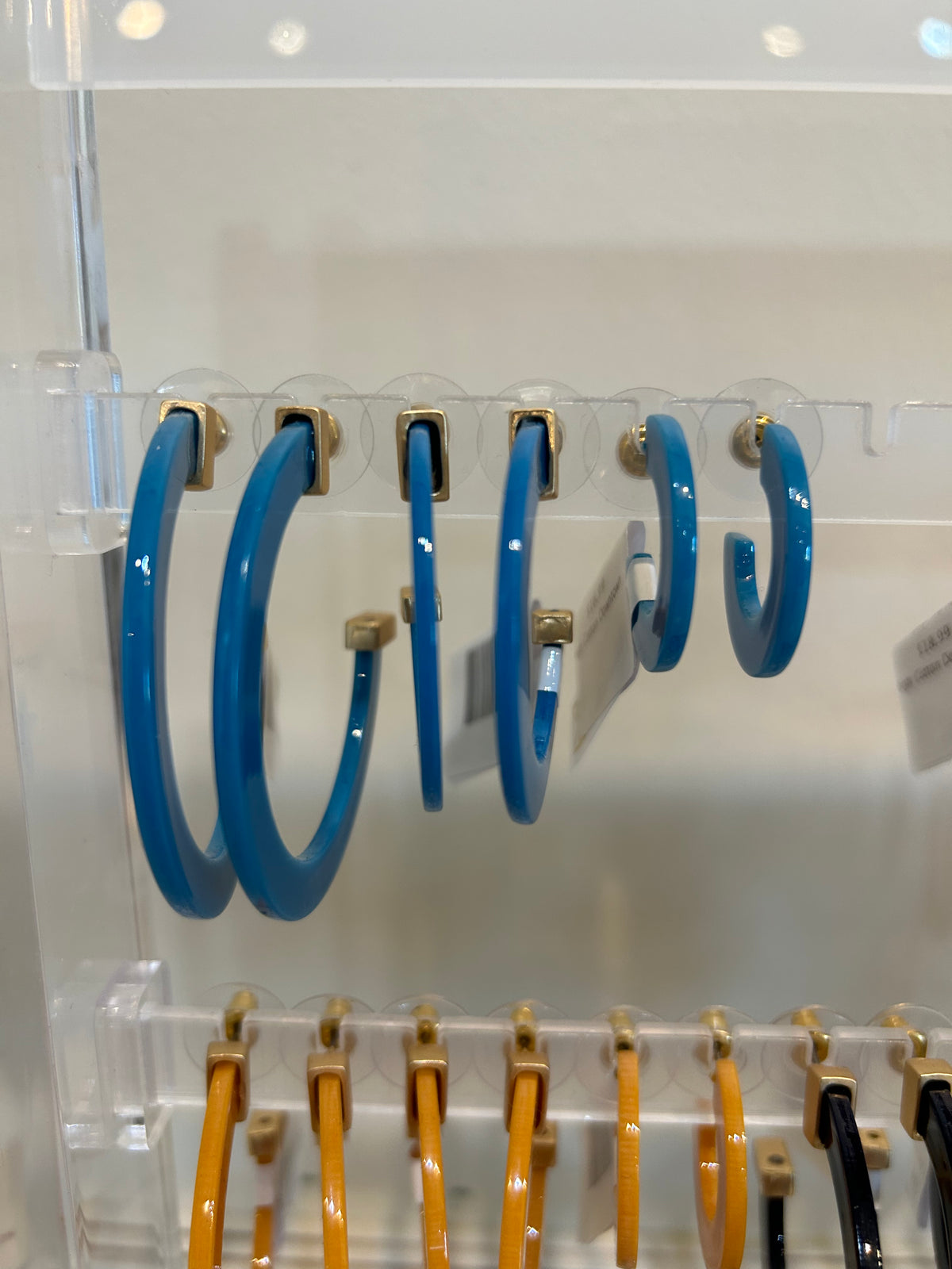 Peacock blue acrylic hoop earrings in three sizes.