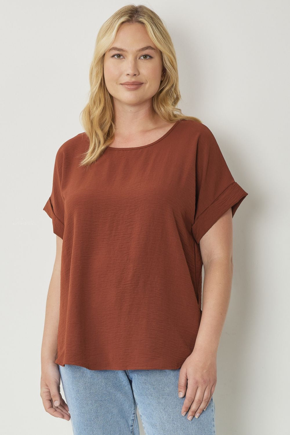 Chocolate scoop-neck top featuring permanent rolled sleeve detail and an asymmetrical hem.