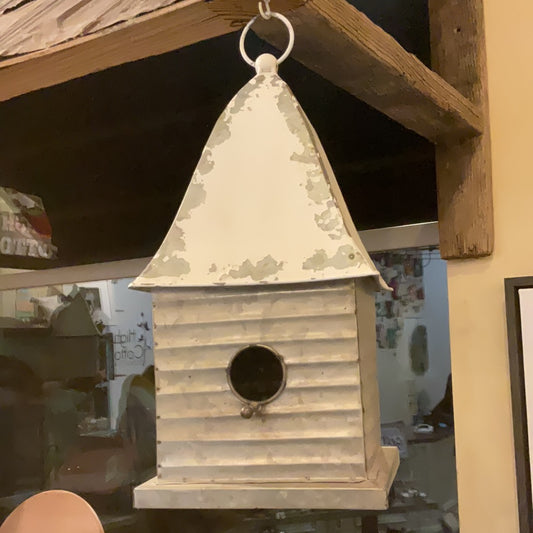 White tin bird house with loop for hanging on top.