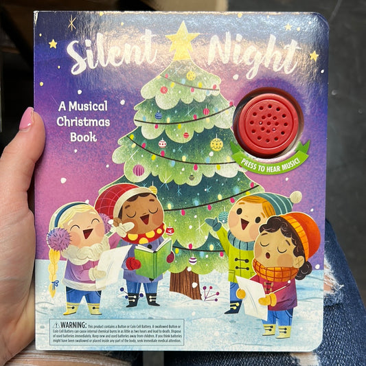Book with a Christmas tree and children singing titling "Silent Night".