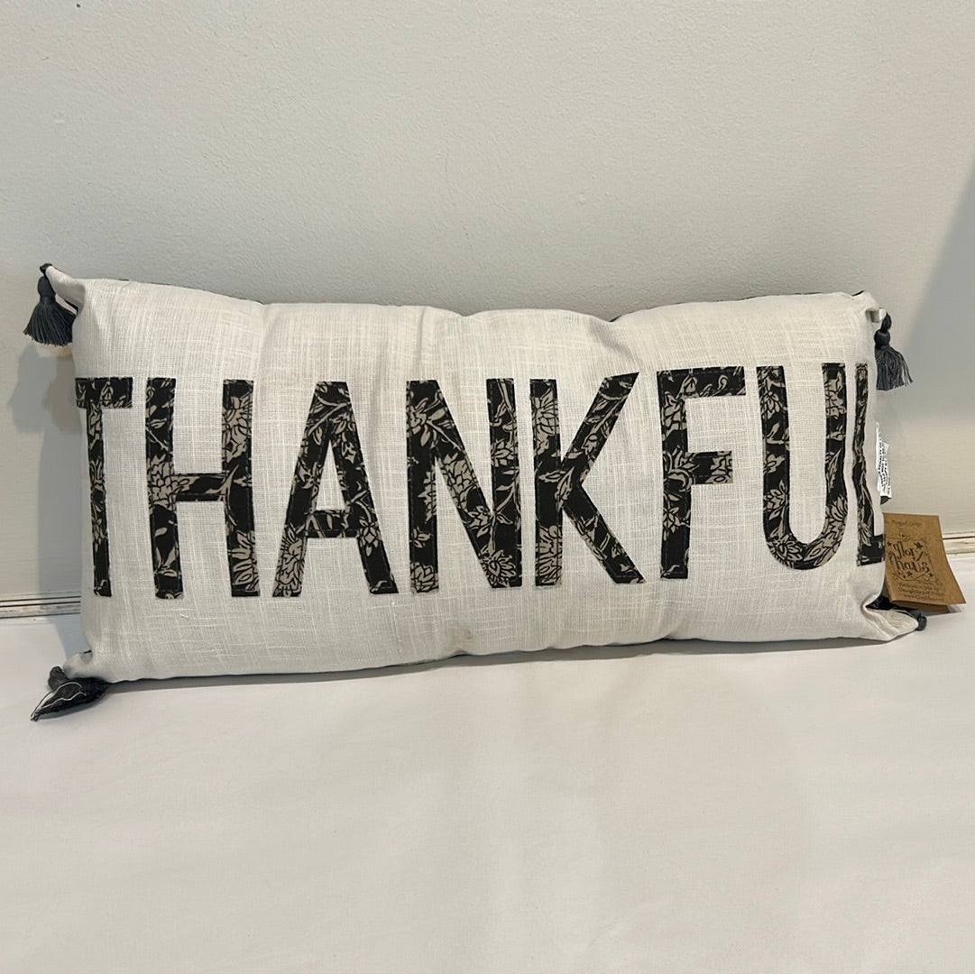 White, long pillow with "Thankful" in black floral fabric.