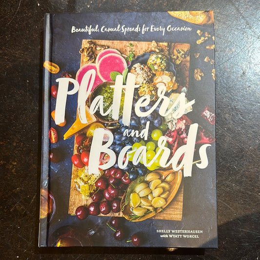 Black book with charcuterie board on cover titling "Platters and Boards".