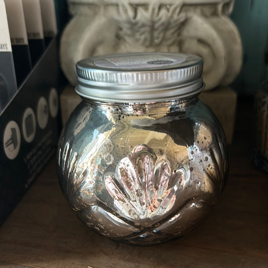 Candle in a blush-toned mercury glass finish and a silver, screw top lid.