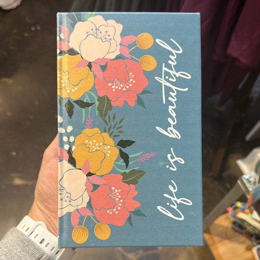 Blue notebook with a floral pattern featuring "Life is Beautiful.