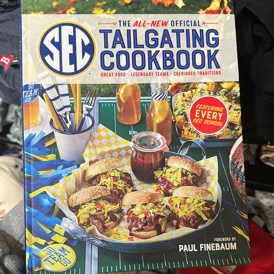 Book with a football theme with burgers titled "The All New Tailgating Cookbook".