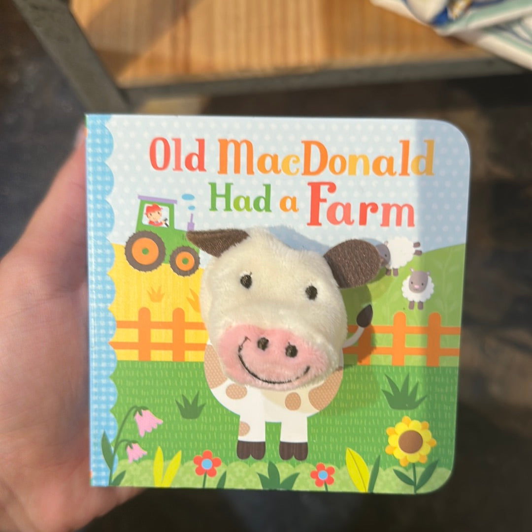 "Old MacDonald Had a Farm" finger puppet book with a cow on a farm.