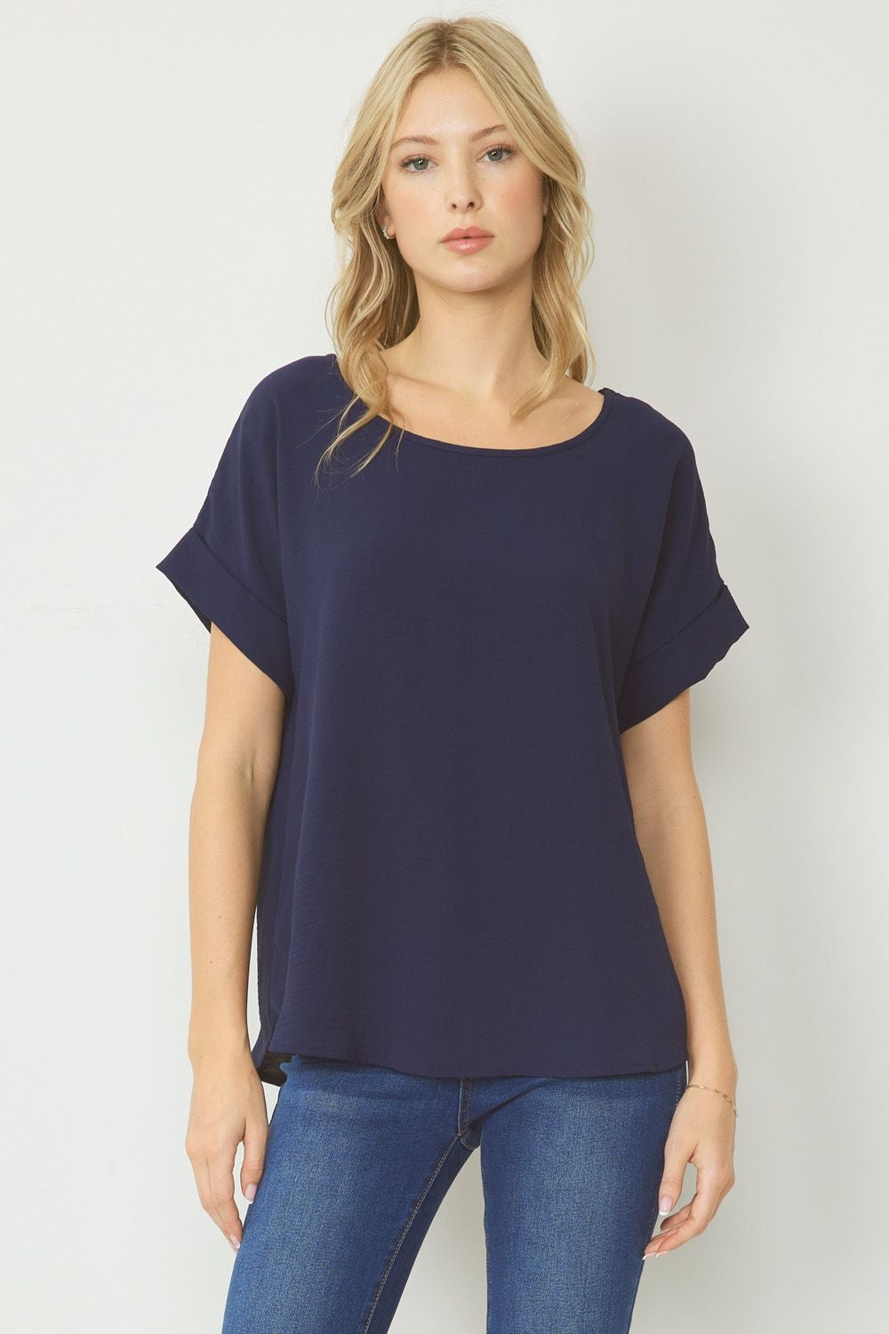 Navy scoop-neck top featuring permanent rolled sleeve detail and an asymmetrical hem.