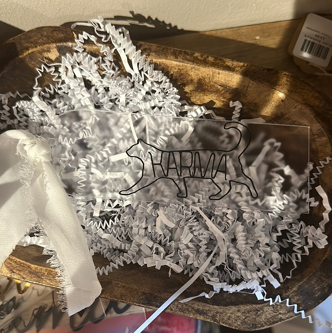 Clear acrylic bookmark with black lettering featuring "KARMA Cat".