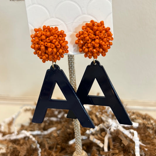 Acrylic earrings with orange beaded studs and navy blue "A".
