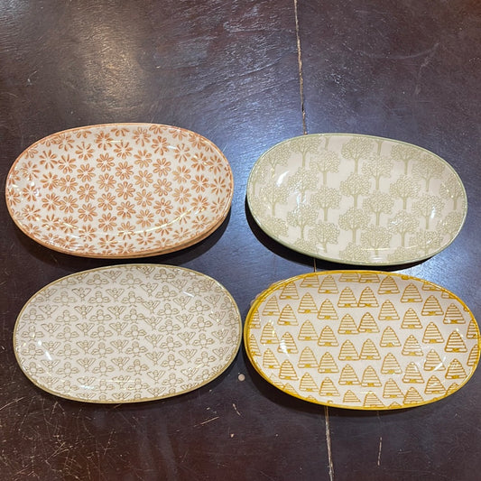 Assorted hand stamped stoneware plates with differeing designs.