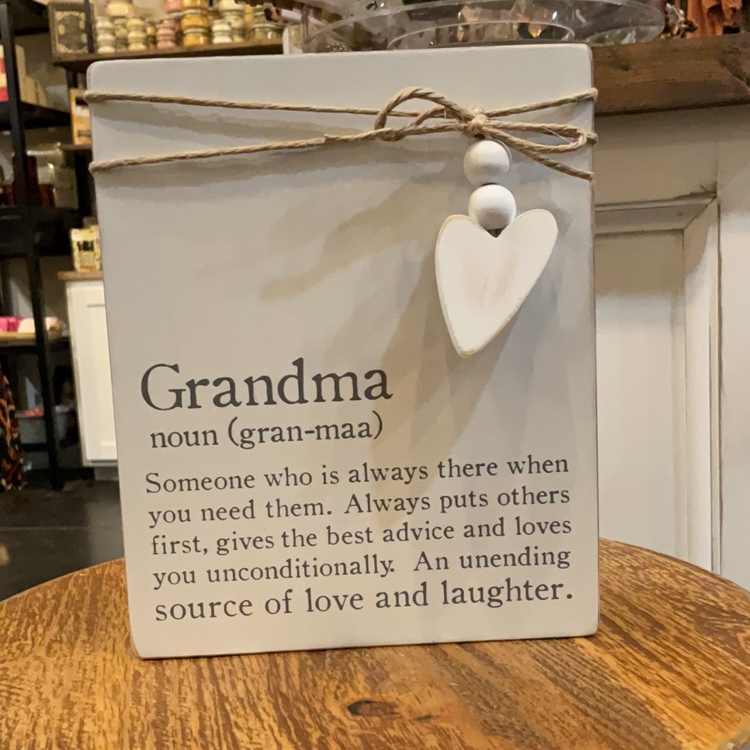 White definition plaques with twine wrapped around with a heart attached featuring "Grandma". Displays" Someone who is always there when you need them. Always puts others first, gives the best advice and loves you unconditionally. An unending source of love and laughter.".