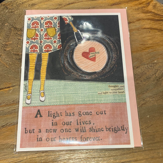 Card displaying a woman with a heart purse featuring "A light has gone out in our lives, but a new one will shine brightly in our hearts forever."
