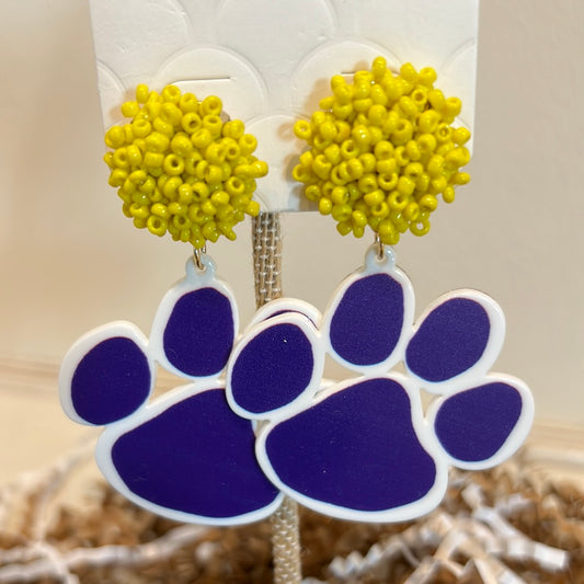 Purple tiger paw dangle earrings with a yellow beaded pompom stud.