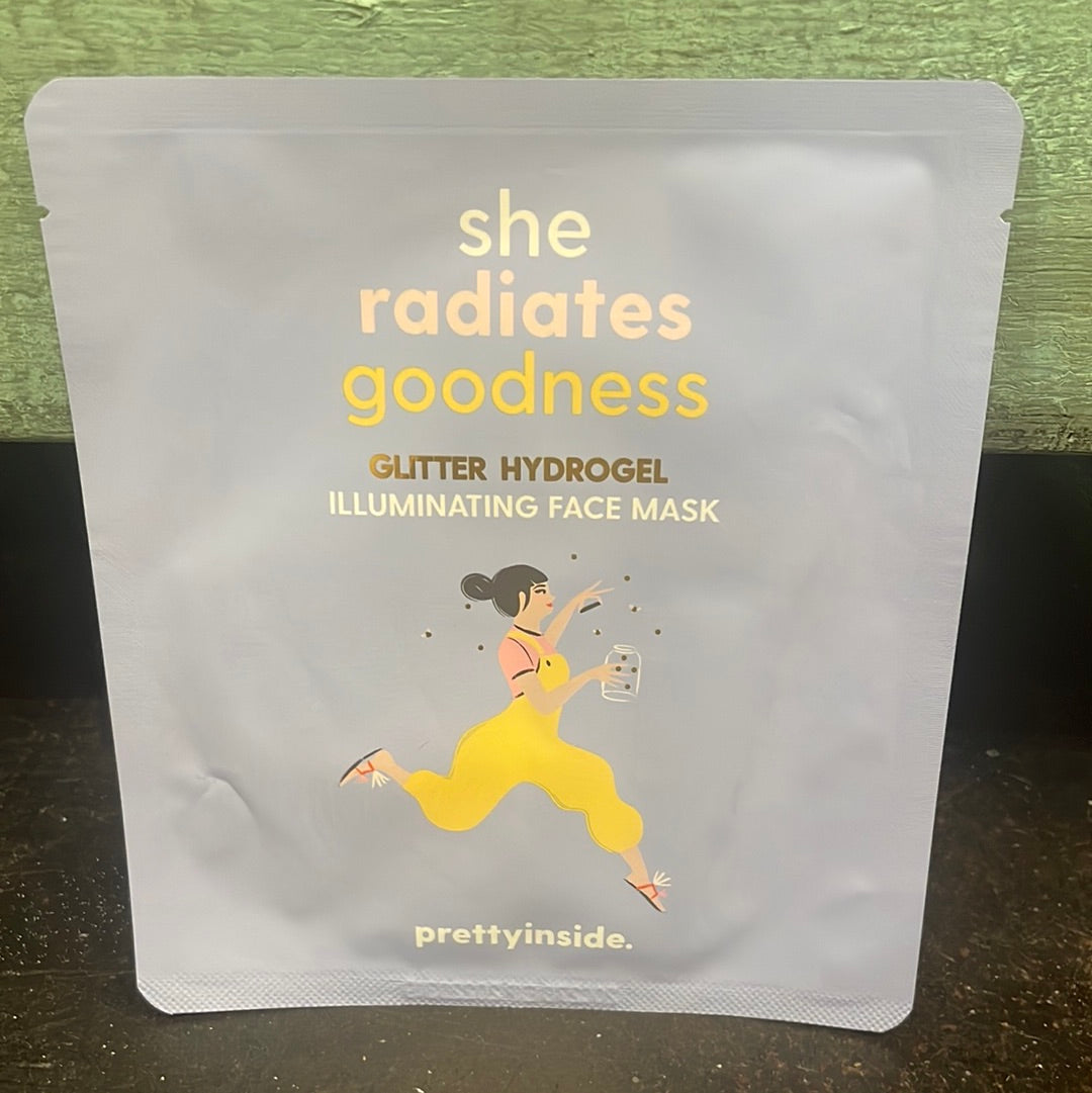 "She radiates goodness" glitter hydrogel illuminating face mask in light blue packaging.