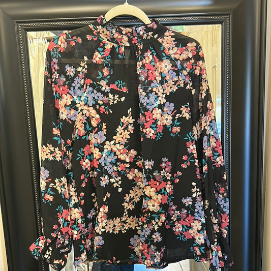 Black turtleneck blouse with yellow, blue, pink, and purple floral pattern.