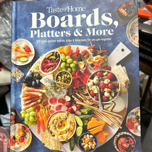 Book featuring a charcuterie board on a blue background with "Taste of Home: Boards, Platters & More" in white lettering.