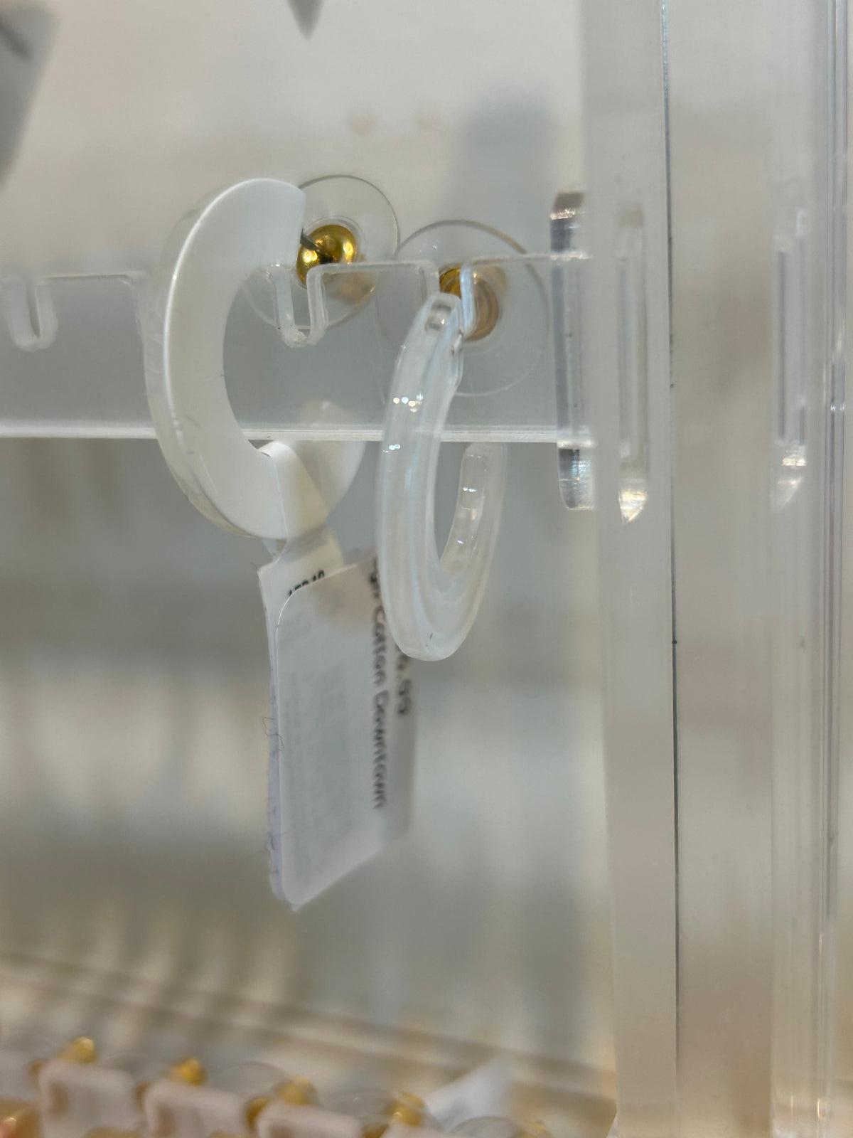 Whte acrylic hoop earrings.