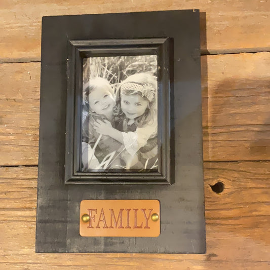 Black Wooden Frame with "Family" on brown leather.