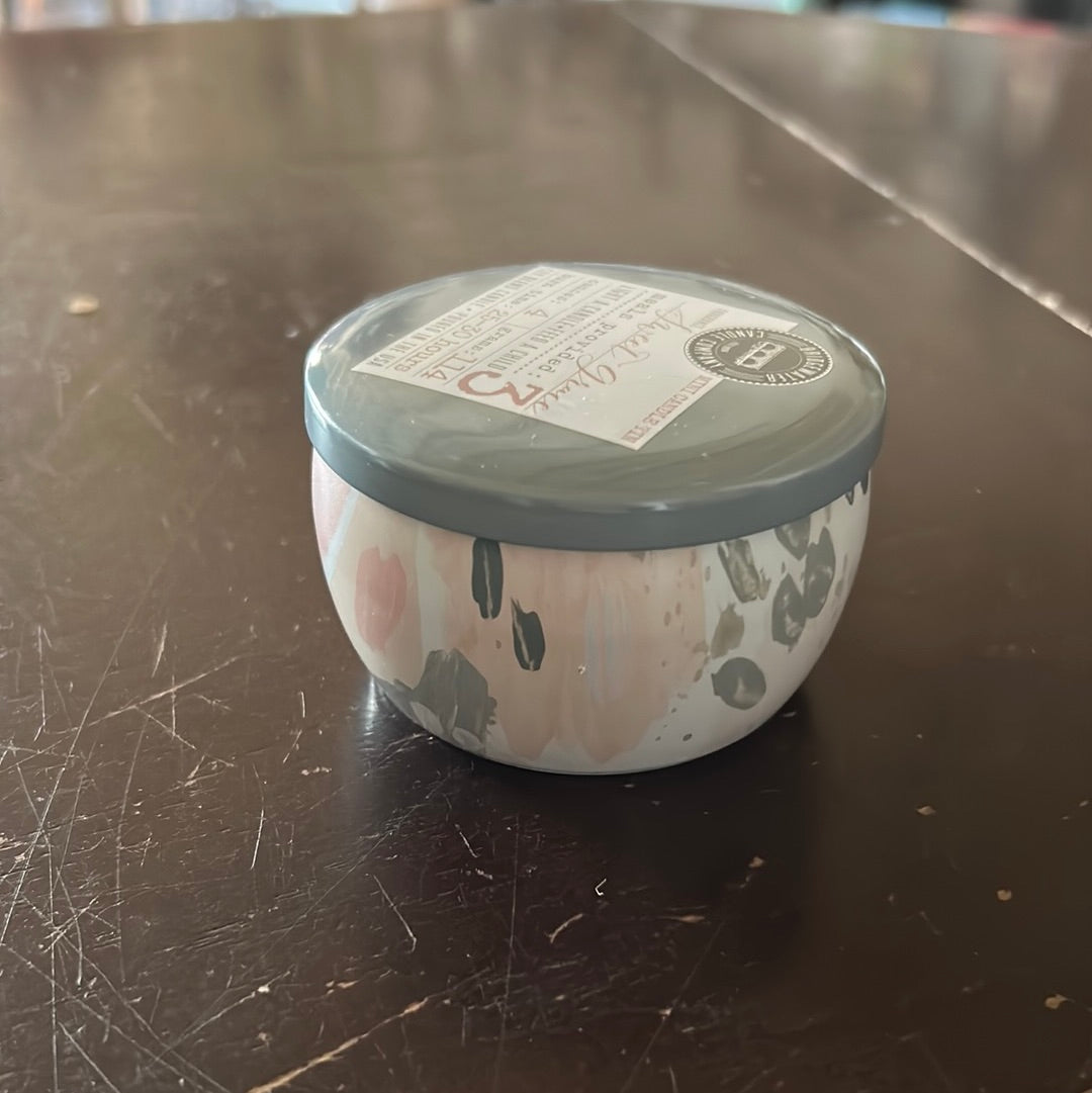 Candle in a tin, travel-sized container.
