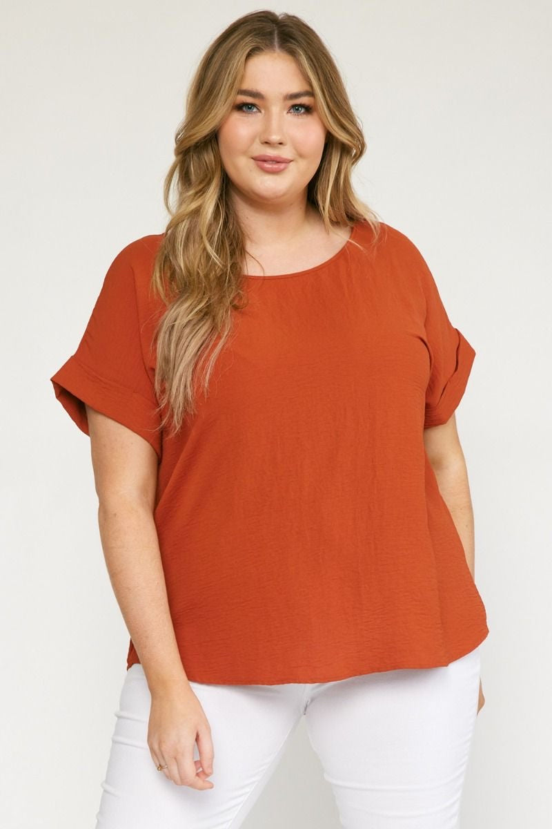 Rust scoop-neck top featuring permanent rolled sleeve detail and an asymmetrical hem.